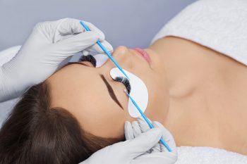 Eyelashes extensions. Fake Eyelashes. Eyelash Extension Procedure. Professional stylist lengthening female lashes. Master and a client in a beauty salon.